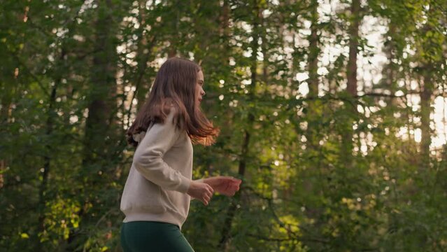 Redhead woman jogging in forest at sunset