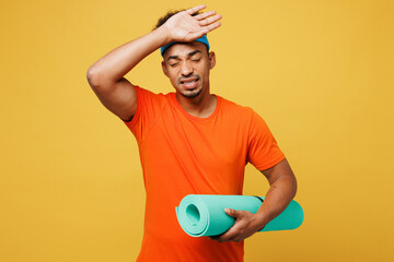 Young sick ill fitness trainer instructor sporty man sportsman wear orange t-shirt put hand on head...