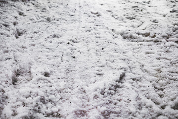 road covered in snow. background of snow on a road. ground view of a snow path in black and white. shoe marks in the snow