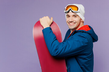 Close up side view smiling man wear warm blue windbreaker jacket ski goggles mask hat hold...