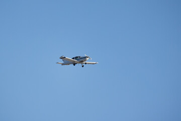 Light single-engine aircraft is in blue sky