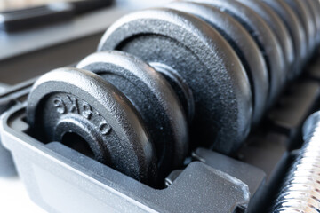 a set of black weights for exercises of various weights in a box