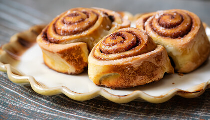 Delicious freshly baked cinnamon rolls on decorative plate.