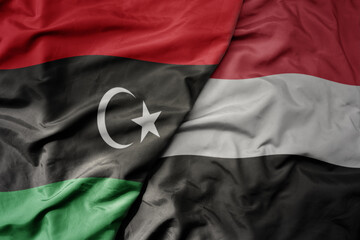 big waving national colorful flag of yemen and national flag of libya .