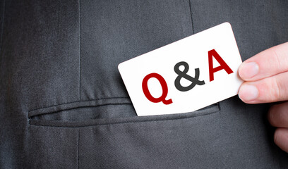 Card with Q AND A text in pocket of businessman suit. Investment and decisions business concept.