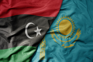big waving national colorful flag of kazakhstan and national flag of libya .