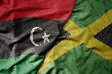 big waving national colorful flag of jamaica and national flag of libya .