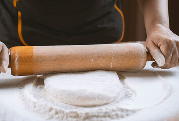 Baker kneading dough for pizza preparation. Chef cook making dough for baking pie on wooden table....