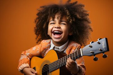 Joyful child playing guitar isolated on flat orange background with copy space. Creative banner for children's music school - obrazy, fototapety, plakaty