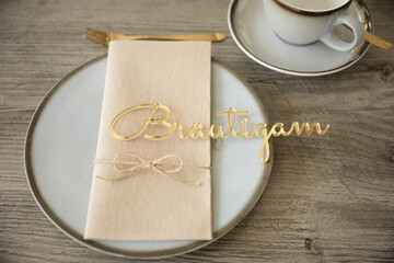 Schriftzug Bräutigam in gold auf der Hochzeitstafel zum Kaffee - 699606877
