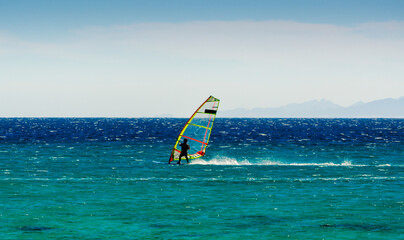 windsurfer on the background of mountains rides on the waves of the Red Sea in Egypt Dahab South...