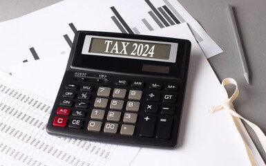TAX 2024 text on calculator with chart on grey background