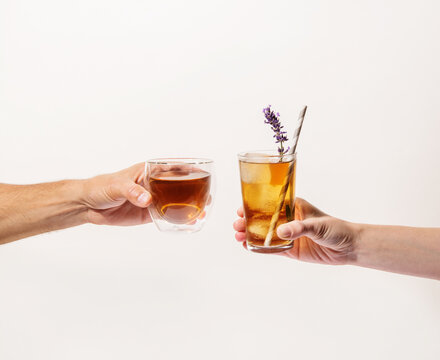 Tho hands holding cups of tea 