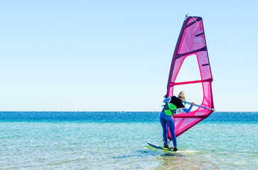 young girl windsurfer beginner learns to ride in the sea in Egypt Dahab South Sinai