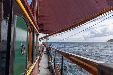 Old Dutch flat bottomed ship sailing under sails on the Baltic Sea