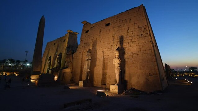 Luxor, Egypt - November 25 2023: Tourists visit the famous Luxor Temple in Egypt with the first pylon, the Ramesses II statues and the Obelisk at night