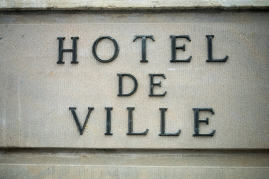 Closeup of french city hall signage on stoned building facade, with text in french, hotel de ville, traduction in english : city hall