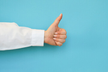 Hand in a white shirt shows a thumbs up gesture on a blue background
