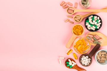 Vitamins and supplements. Variety of vitamin tablets in wooden spoons on a textured background....