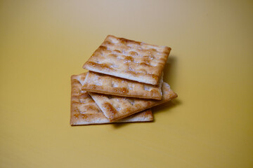 crispy biscuits lying on a yellow background, close up view