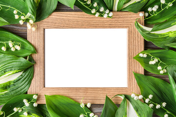 Blank photo frame with spring Lily of the valley flowers on rustic wooden background. Wedding,...