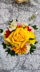 a yellow rose arrangement on a table