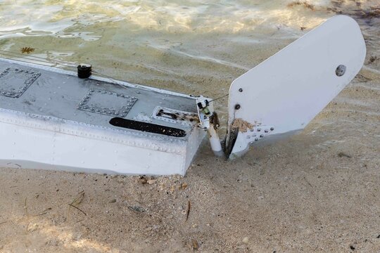 The pontoon and rudder of a float plane touches the sandy beach in Key West, Florida