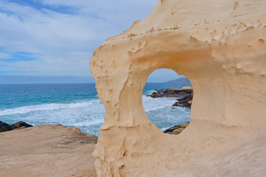 Loch im Sandberg bei Playa del Viejo Reyes nahe La Pared Westk&uuml;ste Fuerteventura mit Blick auf die Berge und Wellen