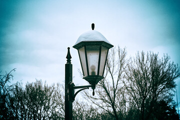 Fototapeta na wymiar Lantern in the park in winter. Vintage style photo