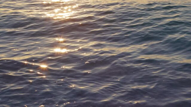 Ocean water surface sunset light ripples sparkles. 4K, h265, 30 fps, 4:2:2 10 bit.
