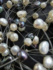 Black and white pearls strung on a fishing line close-up