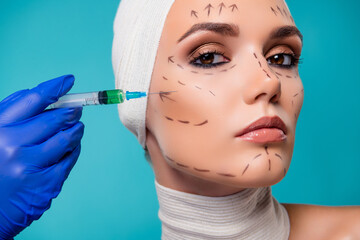 Photo of lady plastic surgery patient having injection with botox filler in cheeks over cyan color...