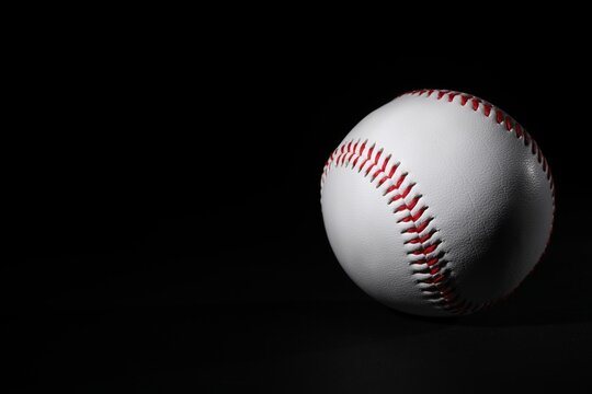 One baseball ball on black background. Space for text