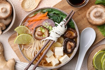 Vegetarian ramen, chopsticks and ingredients on light textured table, flat lay