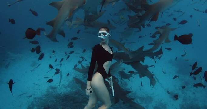 Woman freediver in a clear tropical water with nurse sharks in Maldives