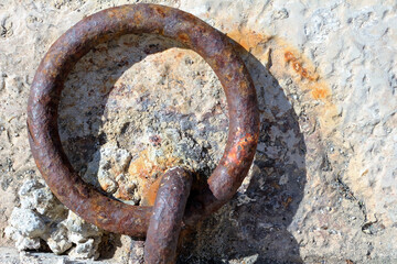 Close up of a mooring ring with a rope. High angle view. Concrete background. Cassis, Boûches du-Rhône, France. - obrazy, fototapety, plakaty