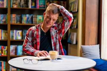 male student in the library who got an idea while reading a book against the background of...