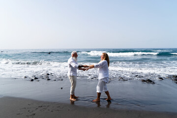 lifestyle of caucasian senior couple dance on beach, happy in love romantic and relax time, tourism of elderly family pleople, leisure and activity travel after retirement in vacations and summer