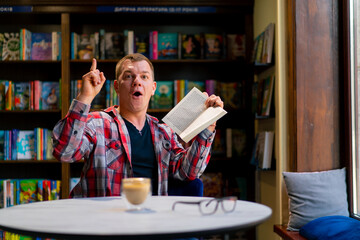 male student in the library who got an idea while reading a book against the background of...