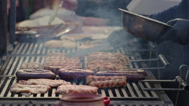 Annual Christmas street fair. Close up barbecue Fast food stall with sausage and pork knuckles in sauce.