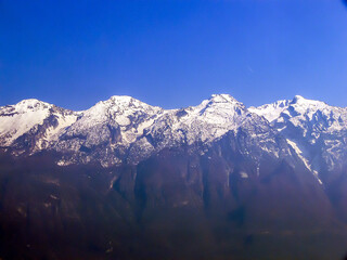 The snow-covered peaks of the Monte Baldo mountain range on Lake Garda in bright sunshine
