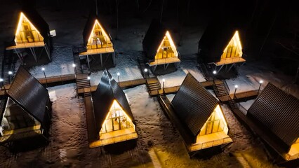 A Frame cabins at night in the winter park