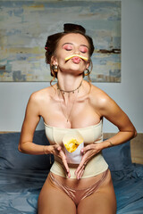 alluring beautiful woman with hair curlers and accessories in corset posing in motion with fries