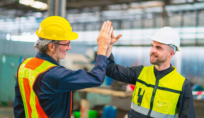 Engineers shake hands after completing work in a heavy machinery factory