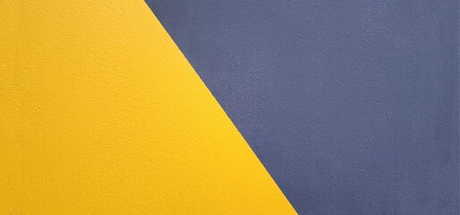 The cement walls are painted blue and yellow. clearly separated on the diagonal It is yellow on the bottom and blue or gray on the top. The background wall is painted differently.
