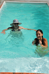 avó e neta brincando juntas em água de piscina 