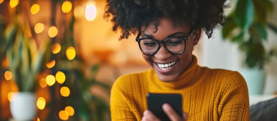 Thrilled black woman receiving online sales update on phone.