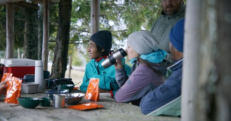 Tourist friends heat hiking food in pouches and rest in gazebo after long walking expedition in the...