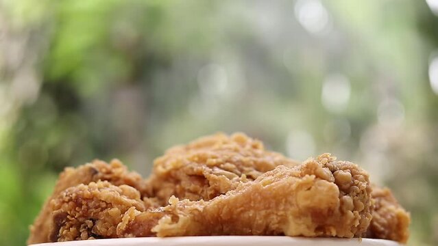 Bucket filled with crispy Kentucky fried chicken with smoke on nature background

