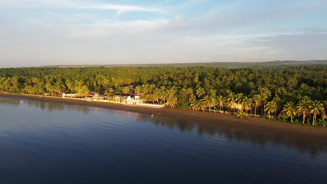 Long span of broad gently sloping strip of fine sand beach lures resort developers to put up structures &ndash; Catanauan, Quezon, Philippines. Aerial drone back tracking shot